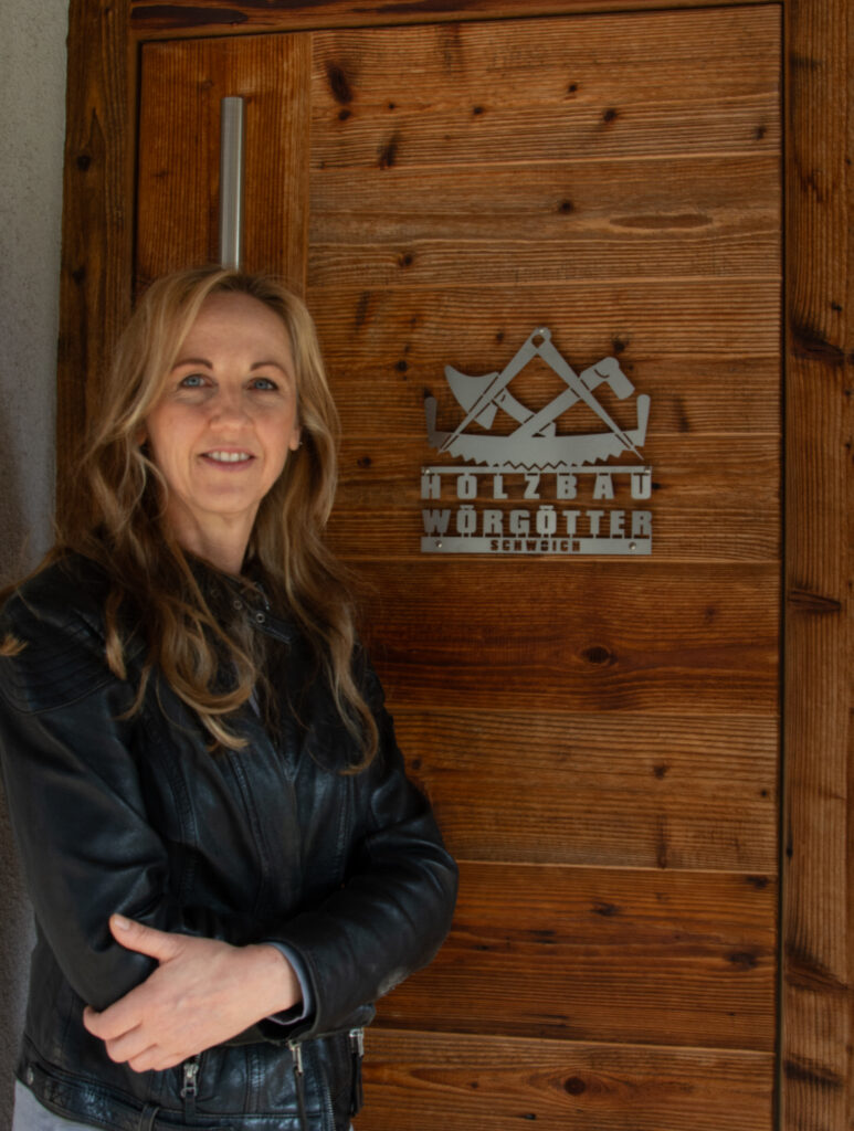 Blonde Dame vor einer Holztür